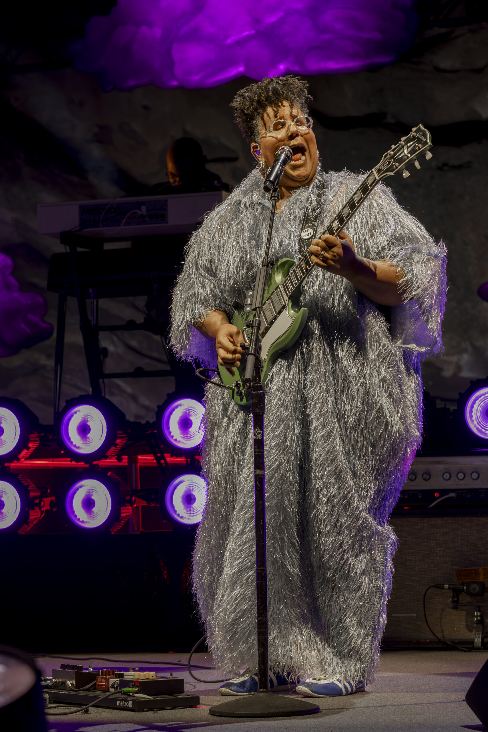 Brittany Howard sings and plays guitar in a silver fringed outfit at Red Rocks.