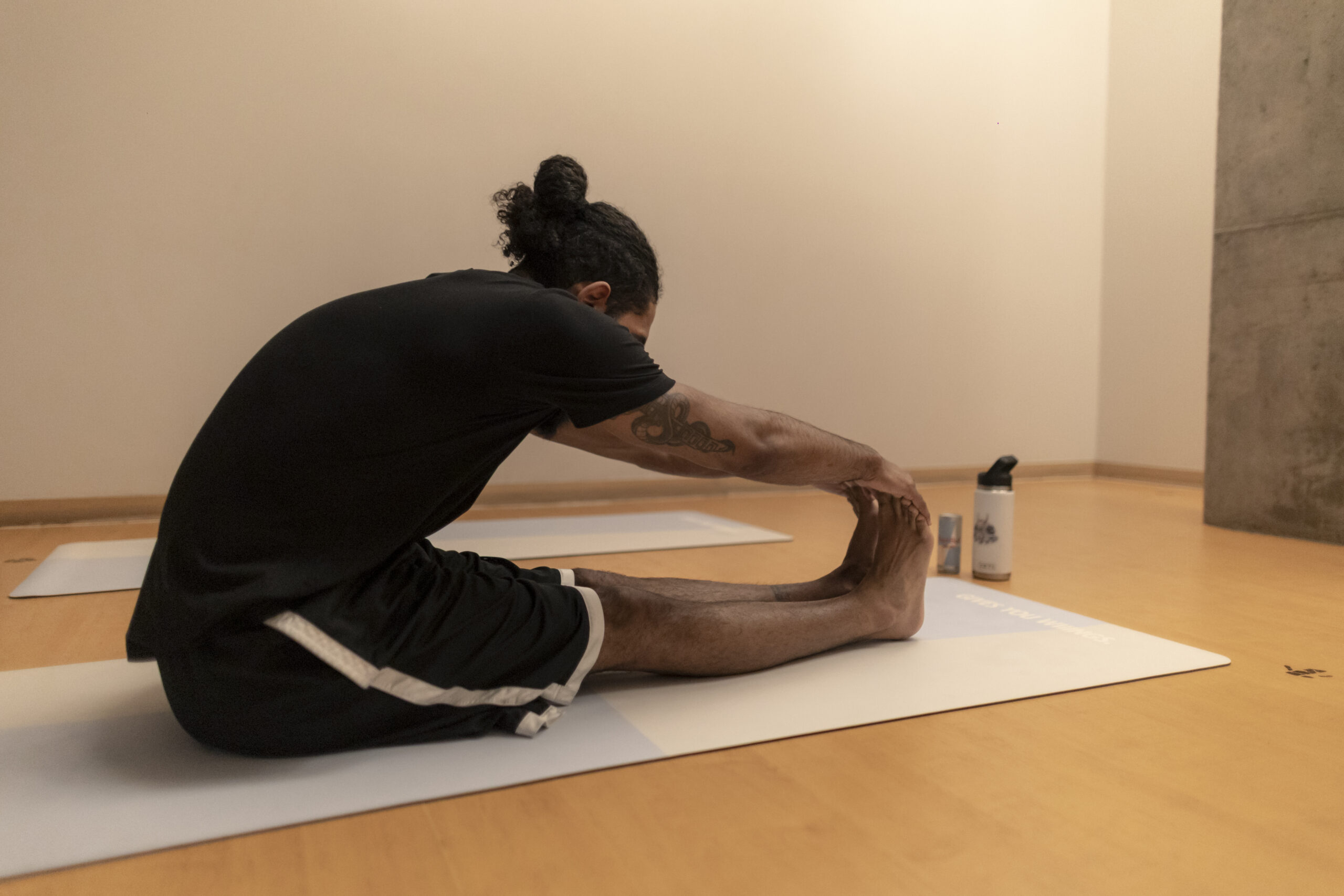 Participant stretches on a mat during a Red Bull event at The River Yoga.