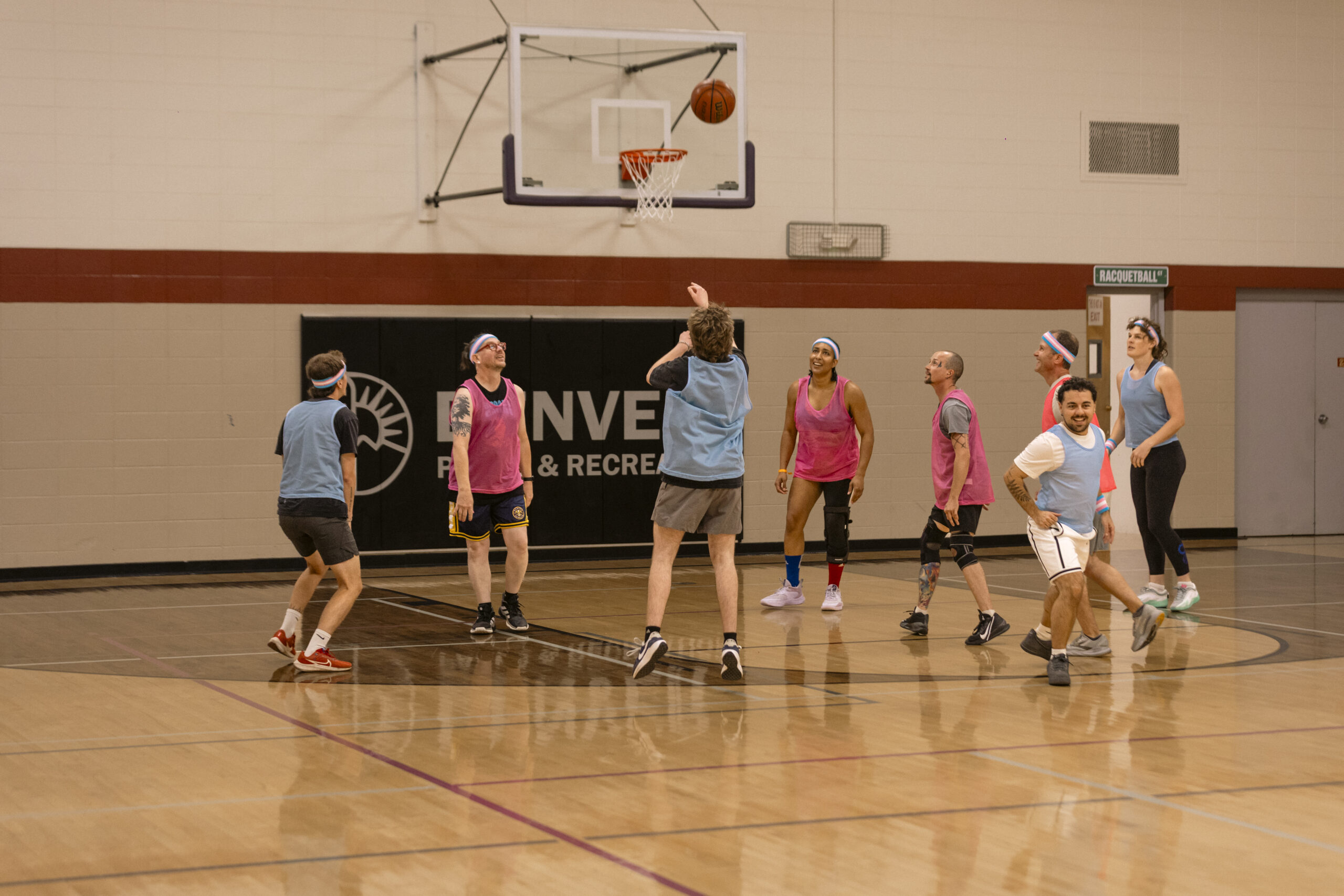 Players watch a jump shot during a trans community basketball game.