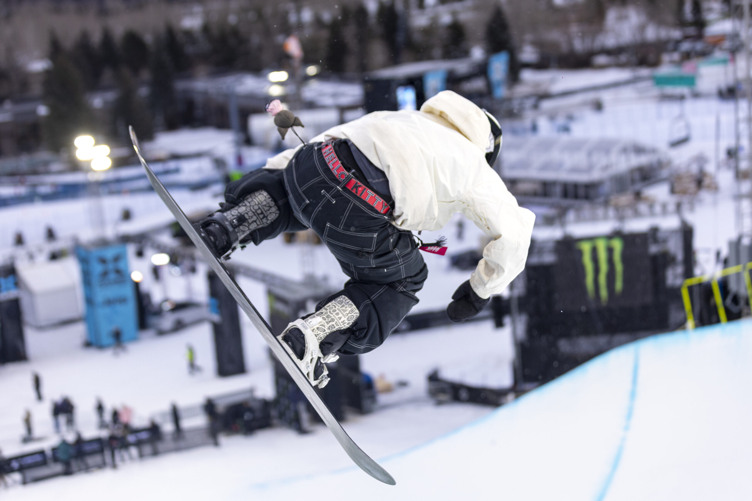 Snowboarder twists above the halfpipe during X Games.