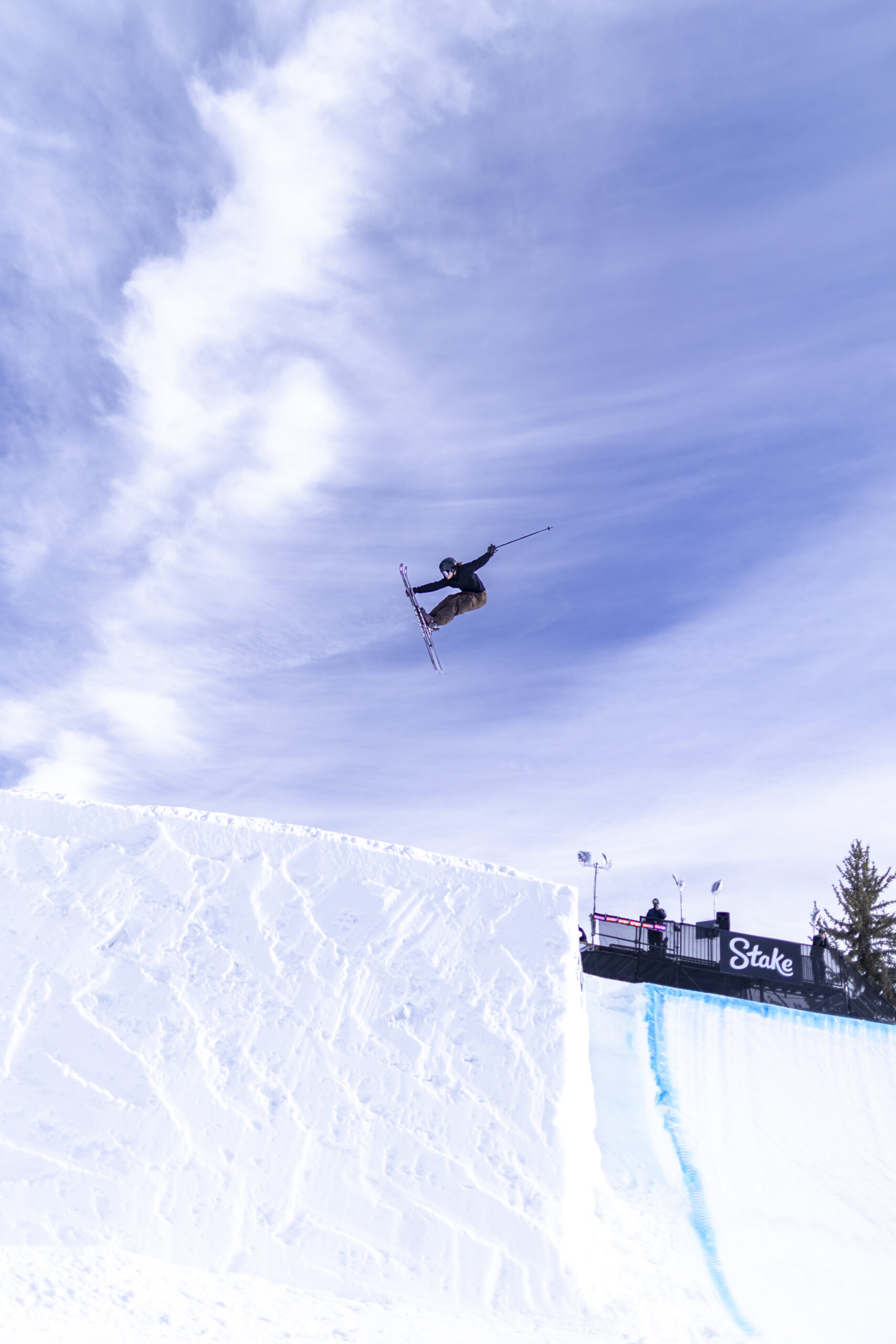 Skier performs an aerial trick above an X Games snow feature.